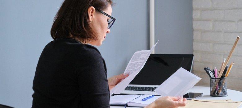 Woman sitting at desk reviewing bills